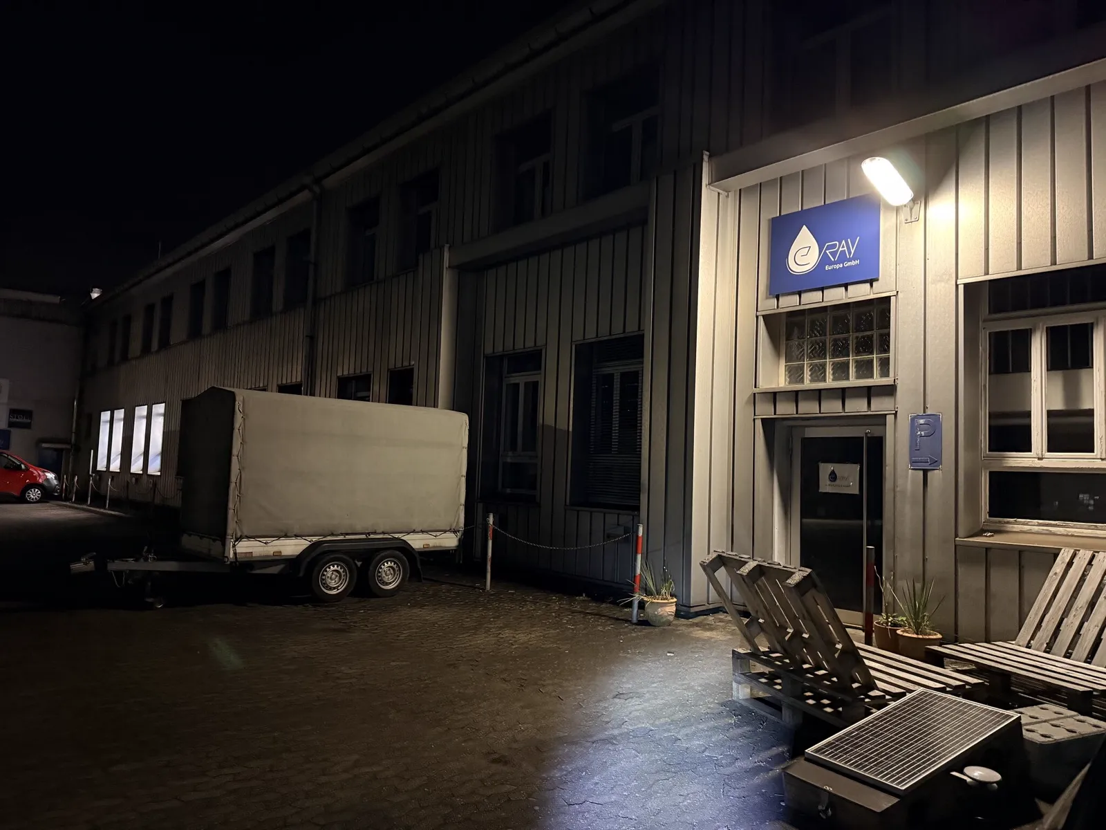Entrance of the new e.Ray location at night, illuminated logo sign