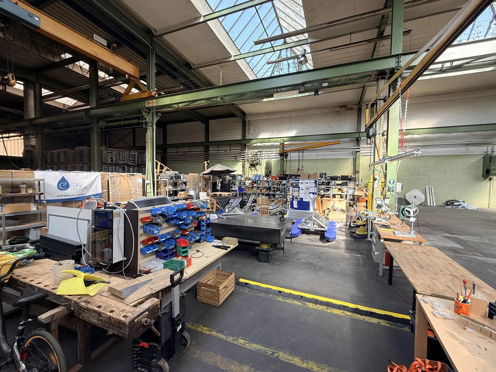 Workshop and hall with workbenches, material shelves and daylight